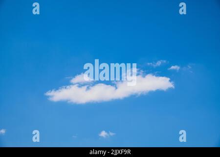Cumulus clouds against bright blue sky Stock Photo