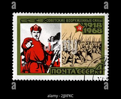 1918 poster and marching military volunteers, 50th anniversary of the Armed Forces of the USSR, circa 1968. canceled postal stamp printed in the USSR Stock Photo