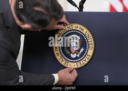 Washington, United States Of America. 28th July, 2022. An aide adjusts the seal on the podium prior to United States President Joe Biden delivers remarks on the Inflation Reduction Act of 2022 in the State Dining Room of the White House in Washington, DC on Thursday, July 28, 2022. This legislation, designed fight inflation and lower costs for American families was announced July 27, 2022 by United States Senate Majority Leader Chuck Schumer (Democrat of New York) and US Senator Joe Manchin III (Democrat of West Virginia). Credit: Chris Kleponis/Pool/Sipa USA Credit: Sipa USA/Alamy Live News Stock Photo