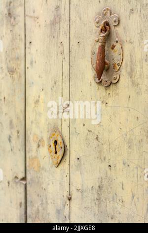 Old rusty knocker and lock, on an old, yellowed wooden door, with copy space Stock Photo