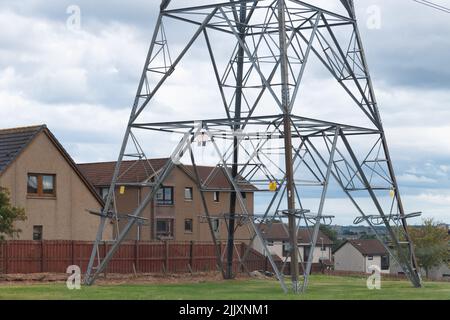 electricity pylon next to houses - Danestone, Aberdeen, Scotland, UK Stock Photo