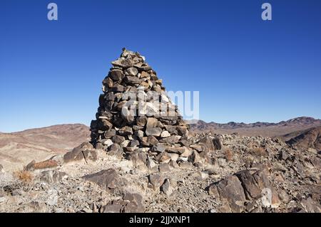 a large cairn or rock pile on the summit of a desert mountain Stock Photo