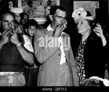 Miss Helen Keller visited the Aborigine Mission at La Perouse yesterday where she was entertained by a three man ' gum leaf' band led by George Longbottom (next to Miss Keller).. Miss Keller ' heard' the band by placing her fingers on Longbottons mouth, larngx and portion of the gum leaf that he was playing. She was able keep perfect time with the players who rendered 'Lead Kindly Light' ... April 11, 1948. (Photo by Frederick John Halmarick/Fairfax Media). Stock Photo