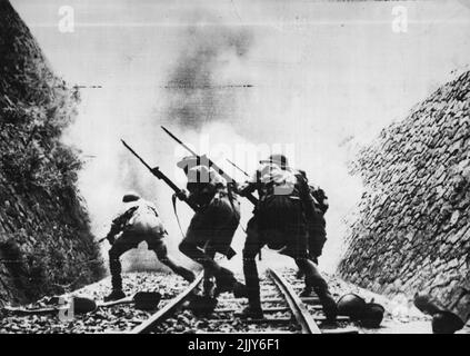 Men of the 8th Army charge through a railway cutting with fixed bayonets to storm an enemy stronghold at a railway station. Allied forces have opened a new offensive on all Sicily fronts, U.S. troops have captured San Stefano and Mistretta and the 8th Army is making steady progress in the face of desperate German resistance. (3.8.43). October 18, 1943. (Photo by British Official Photo). Stock Photo