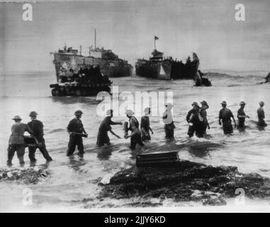 British Pass Shells Up Sicily Beach -- British Tommies form a chain to pass ammunition ashore somewhere in Sicily. In deeper water a tank moves shoreward from landing craft. This is an official British photograph. July 14, 1943. (Photo by AP Wirephoto). Stock Photo
