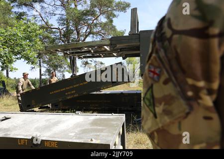 British soldiers assigned to the 26th Regiment Royal Artillery load training rounds into their M270 Multiple Launch Rocket System (MLRS) In the Grafenwoehr Training Area, Germany, July 18, 2022. Dynamic Front 2022, led by 56th Artillery Command and U.S. Army Europe and Africa directed, is the premiere U.S.-led NATO Allies and Partners-integrated fires exercise in the European theater focusing on fire interoperability and increasing readiness, lethality and interoperability across the human, procedural and technical domains.(U.S. Army photo by Maj. Joe Bush) Stock Photo