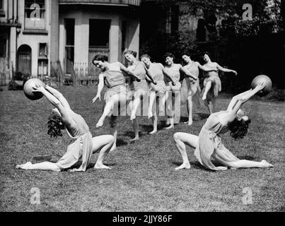 Ready For Next Month's Display -- Graceful action by some of the teachers during a rehearsal. In the garden of a house in Holland Park, London, a number of teachers of the Women's League of Health and Beauty are rehearsing for their annual demonstration at Olympia next month. They will lead the thousands of League members at the demonstration. May 6, 1936. (Photo by Fox). Stock Photo