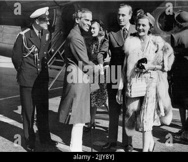 Mountbatten Arrives From India - V.K. Krishna Menon, high Commissioner for India (Second from left), shakes hands with Earl Mountbatten of Burma (second from right), on the arrival of the latter at Northolt airport, Middlesex, this evening June 23, from India, after handing over his office of Governor General. The Duke of Edinburgh stands at left and at right is Lady Mountbatten. May 27, 1933. (Photo by Associated Press Photo). Stock Photo