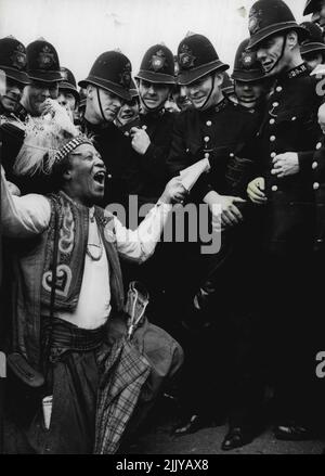 Laying Down The Law? -- Prince Monolulu, England's most familiar racing Tipster was one of the first on the course at Epsom this morning, Tipping the winner (?) of today's Derby race. He is here ***** seen trying to sell a tip to some of the Hundreds of police ***** who were on duty. May 1, 1938. (Photo by Keystone). Stock Photo