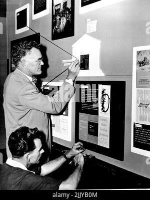 The Director of the National Art Gallery, Mr Hal Missingham with Jack McGeorge of the gallery workshop, preparing a display panel showing the educational activities of the gallery, in the foyer today. It will be on display during Education week which opens on the 15th. August 13, 1954. (Photo by Frank Albert Charles Burke/Fairfax Media) Stock Photo