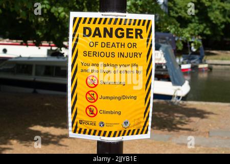 Windsor, Berkshire, UK. 28th July, 2022. Following the body of a man being recovered from the River Thames near Baths Island in Windsor last week, new danger signs have been put up next to the River Thames warning people of the dangers of swimming and diving into the River Thames. Credit: Maureen McLean/Alamy Live News Stock Photo