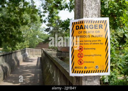 Windsor, Berkshire, UK. 28th July, 2022. Following the body of a man being recovered from the River Thames near Baths Island in Windsor last week, new danger signs have been put up next to the River Thames warning people of the dangers of swimming and diving into the River Thames. Credit: Maureen McLean/Alamy Live News Stock Photo