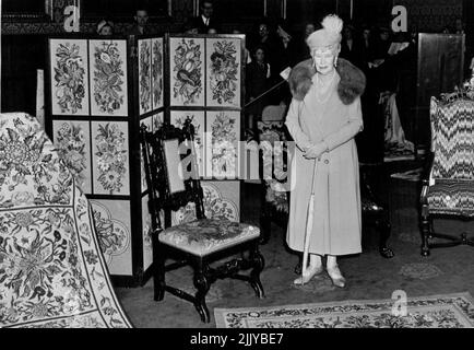 Queen Mary Opens Needlework Exhibition, Royal School, At St. James' Palace Queen Mary standing by some of her own embroidery work at today's opening. H.M. has four works on show: the carpets, the screen and the chair. Queen Mary's latest work is dated 1950. Queen Mary today opened an exhibition of embroidery by the Royal School of Needlework at St James' Palace. The Coronation Robes are also on view. April 12, 1951. (Photo by Fox). Stock Photo