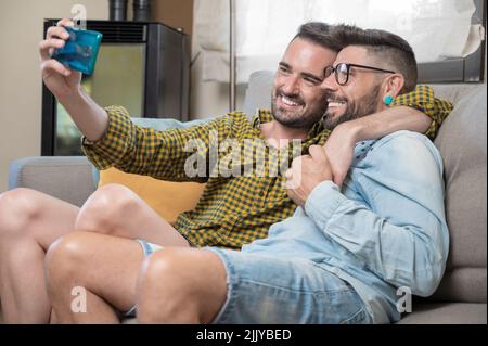 Young smiling gay couple taking selfie at home. High quality photography Stock Photo