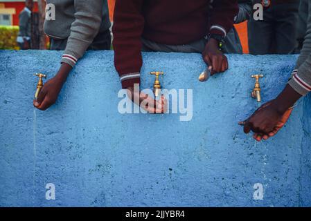 Lack of Water in Africa. African children holding hands by source of water. Illustration photo. Drought in Africa Stock Photo