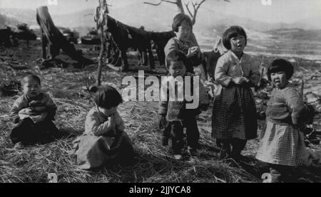 Hopeful Camp Followers -- Korean waifs gather on edge of U.S. 3rd Division tank force encampment Thursday on Korea's central front as they seek the inevitable food handout and a chance to warm themselves. The camp in on the site of their former homes, destroyed as the tide of war rolls over the area. February 12, 1951. (Photo by AP Wirephoto). Stock Photo