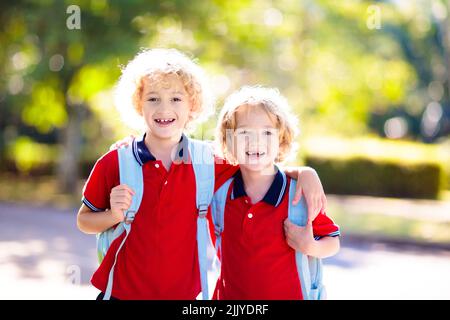 Children go back to school. Start of new school year after summer vacation. Boy and girl with backpack and books on first school day. Stock Photo