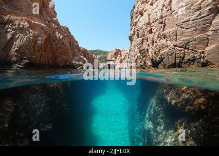 Narrow passage in rocky coast with a boat, split level view over and under water surface, Mediterranean sea, Spain, Costa Brava, Catalonia Stock Photo