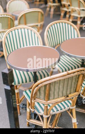 Green and ivory rattan French cafe chairs in Paris, France Stock Photo