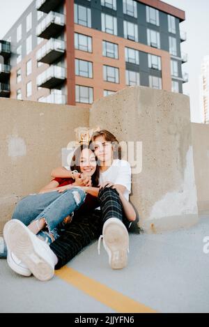 teenage boyfriend and girlfriend embracing on a garage rooftop Stock Photo