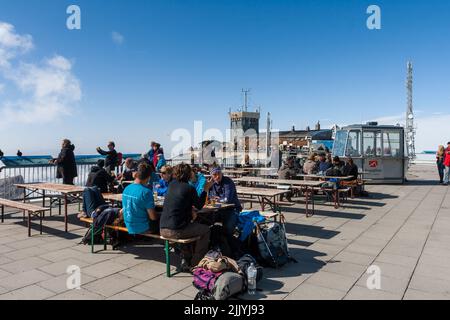 Tourists Dining at Restaurant on top of Zugspitze Mountains. Bavaria, Germany. Technical Research Centre.Telecommunications Antennas with Radar receiv Stock Photo