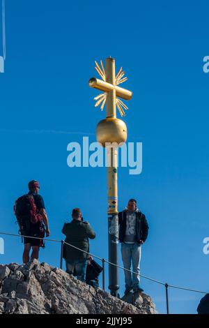 Visitors at Golden summit cross, Zugspitze, the peak of Germany and Wetterstein Mountains near Garmisch-Partenkirchen Stock Photo