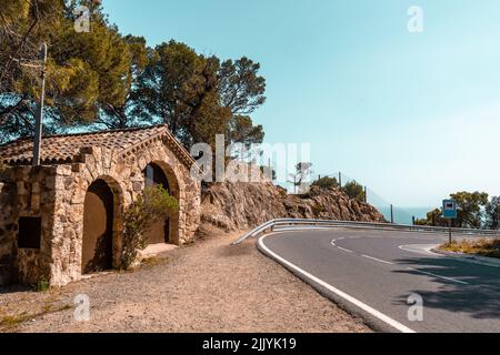 Sharp street turn on the coastal road. Viewpoint with stone wall building Stock Photo