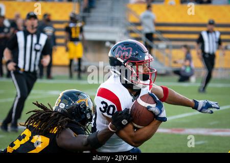 Montreal Alouettes wide receiver Reggie White Jr (84) carries the ball past  Hamilton Tiger-Cats defensive back Cariel Brooks (26) during first half  exhibition CFL football action in Hamilton on Saturday, May 28