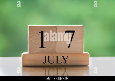 July 17 calendar date text on wooden blocks with blurred background park. Concept Stock Photo