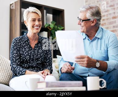 Sometimes you need someone to help you with paperwork. a senior male realtor going through paperwork with a client. Stock Photo