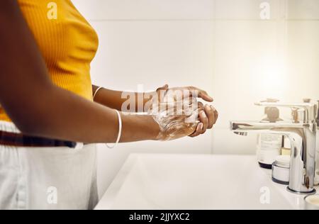 Woman washing, cleaning and rubbing hands with soap and water for good personal hygiene, safety and health in a bathroom at home. Killing germs, virus Stock Photo