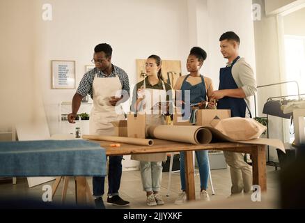Fashion, design and style with a young and diverse professional team working in a creative startup, textile workshop. Group of work colleagues Stock Photo