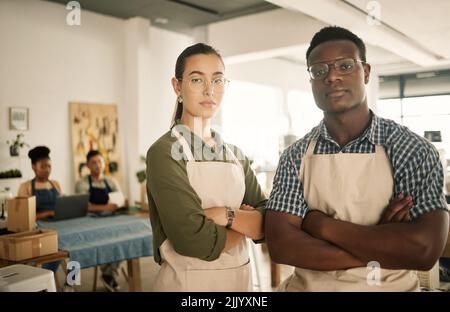 Fashion, design and style with two diverse and professional team members standing arms crossed and working in a creative workshop. Serious and Stock Photo