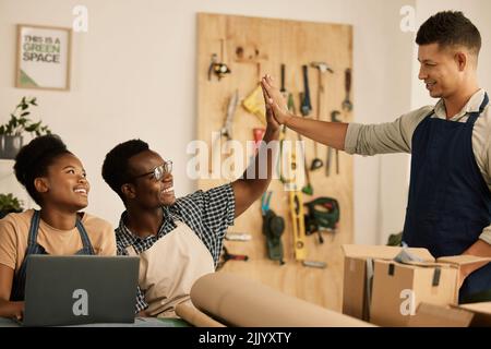 Teamwork and success or celebration with a high five. Fashion, design and style with diverse and professional team members working in a creative Stock Photo