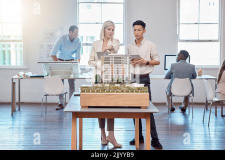 Confident business professionals in the field of architecture working together on building designs in a modern office. Team of male and female Stock Photo