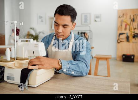 Fashion designer, young man and creative student in a workshop designing clothes. Factory worker, tailor and apprentice learning sewing machine skills Stock Photo