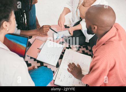 Group of students and business people brainstorming and strategizing for school project or sharing ideas, taking notes in book, digital tab and laptop Stock Photo