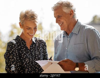 New happy beginnings start today. a senior male realtor going through paperwork with a client. Stock Photo