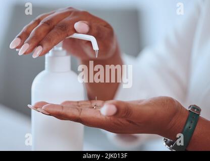 Closeup of beautiful female hands washing using hand sanitizer with care. African American lady cleaning her skin for health and wellness reasons. A Stock Photo