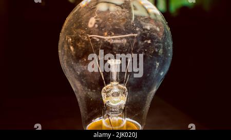 Dirty old light bulb closeup on dark background Stock Photo