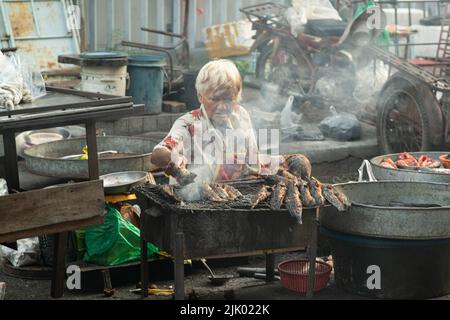 PHICHIT , THAILAND - AUGUST 29,2020 : Unidentified elderly vendors grill catfish for sale. or barbecue in the morning market This food is popular. Stock Photo