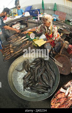 PHICHIT , THAILAND - AUGUST 29,2020 : Unidentified elderly vendors sell grilled catfish and a variety of fresh fish in the morning market. Stock Photo