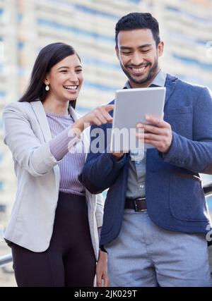 I just received this feedback. two coworkers using a digital tablet together. Stock Photo
