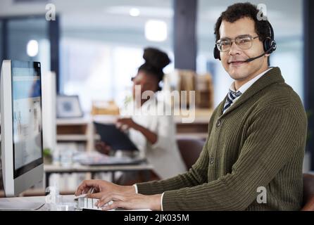 Hes a happy employee. two call center agents working in an office. Stock Photo
