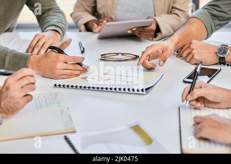 cant find the rhyme in their reason. a group of unrecognizable businesspeople discussing strategies in a modern office. Stock Photo