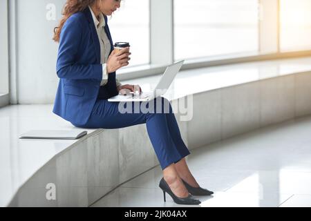 Cropped image of female business executive drinking coffee and working on computer Stock Photo