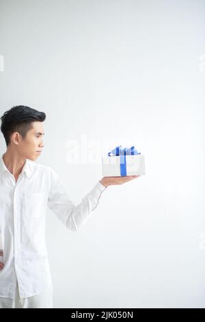 Vietnamese young man looking at giftbox on his hand Stock Photo
