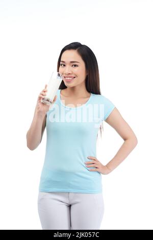 Portrait shot of attractive young woman looking at camera with charming smile while drinking milk, isolated on white background Stock Photo