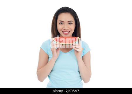 Pretty dark-haired woman posing for photography with charming smile while holding slice of watermelon in hands, isolated on white background Stock Photo