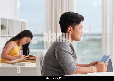 Schoolboy using tablet computer in the class Stock Photo